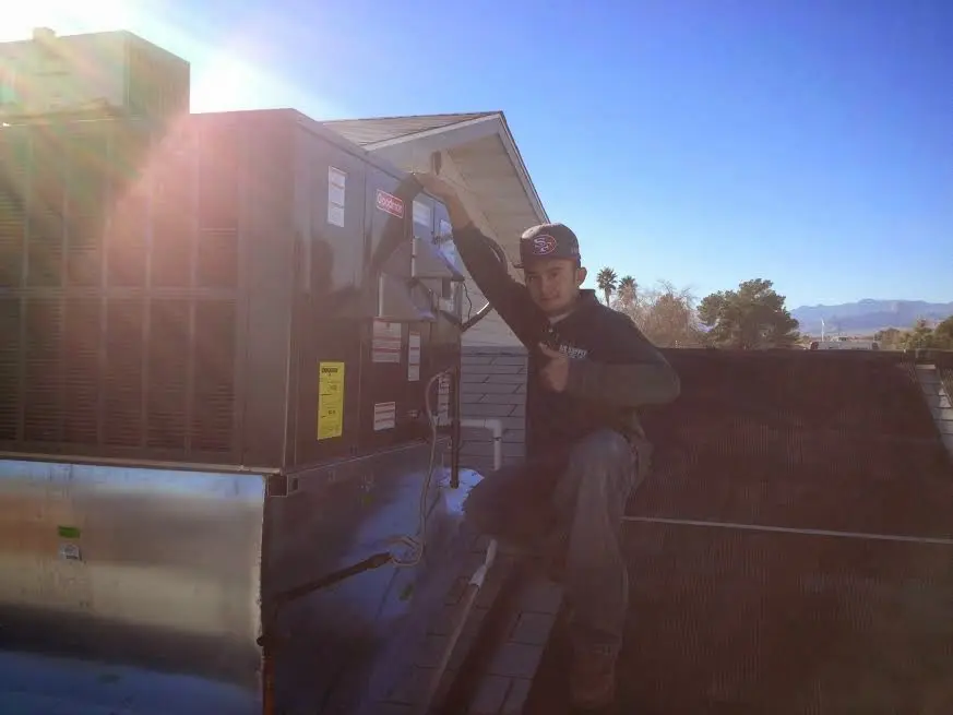 HVAC technician performing Boiler Repair on a rooftop unit in Mount Airy
